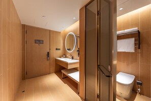 Une salle de bain moderne avec une douche à parois de verre, un meuble-lavabo avec un miroir et des toilettes.