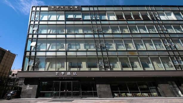 A modern hotel building with a glass facade, a sign for the 'J Hotel', and a visible entrance. - JI Hotel (Beijing)