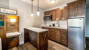 A modern kitchen with wooden cabinets, stainless steel appliances, and pendant lighting. - MainStay Suites Moreno Valley Near March Air Reserve Base (Moreno Valley)