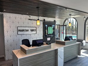 A reception desk with a sign reading "MAINSTAY SUITES" and "LIVE LIKE HOME". - MainStay Suites Moreno Valley Near March Air Reserve Base (Moreno Valley)