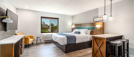 Una habitación de hotel moderna con una cama, un escritorio, una silla y una mesita.