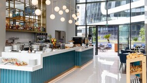 A modern bar area with a counter, various food items, and a coffee machine.