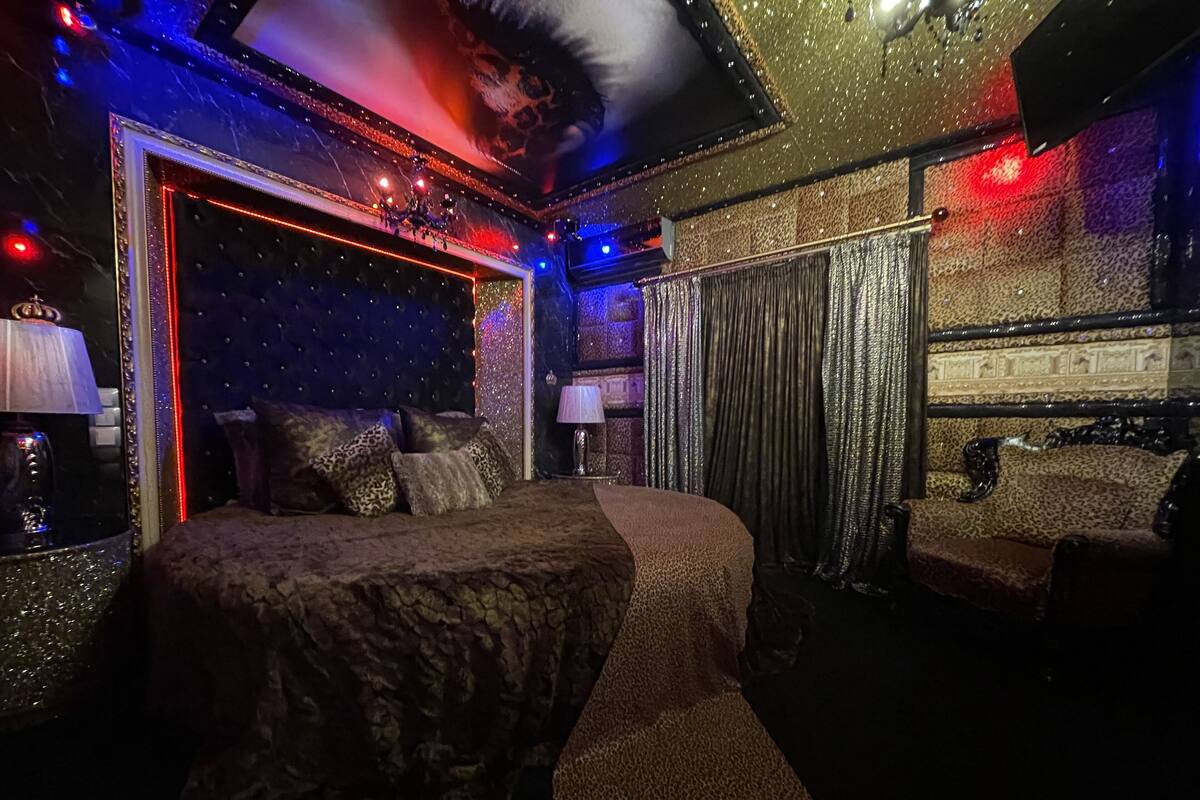 A luxurious bedroom with a large bed, a mirror, and a plush sofa.