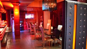 Ein Restaurant mit Barbereich, Sitzgelegenheiten und einem Fernsehbildschirm.