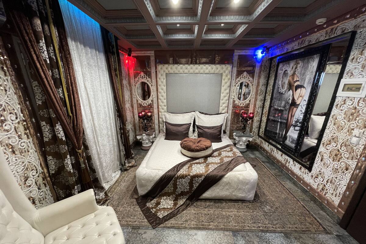 A luxurious bedroom with a large bed, ornate curtains, and a decorative mirror.