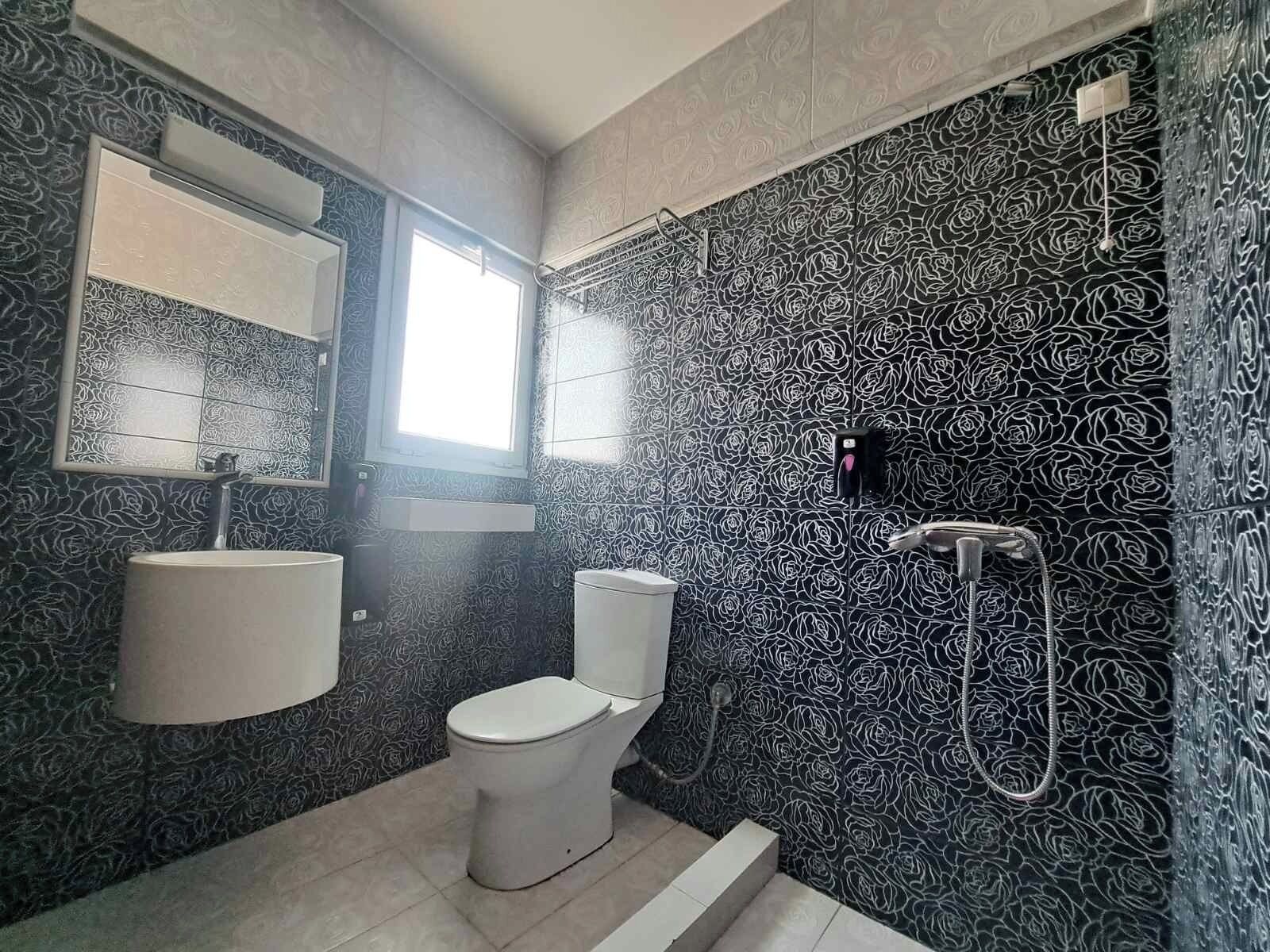 A bathroom with a toilet, sink, and shower.