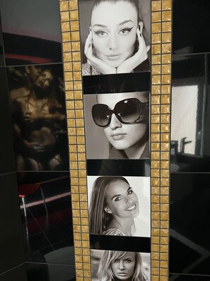 A wall with a series of framed photographs. - X Hotel Salem (Elliniko-Argyroupoli)