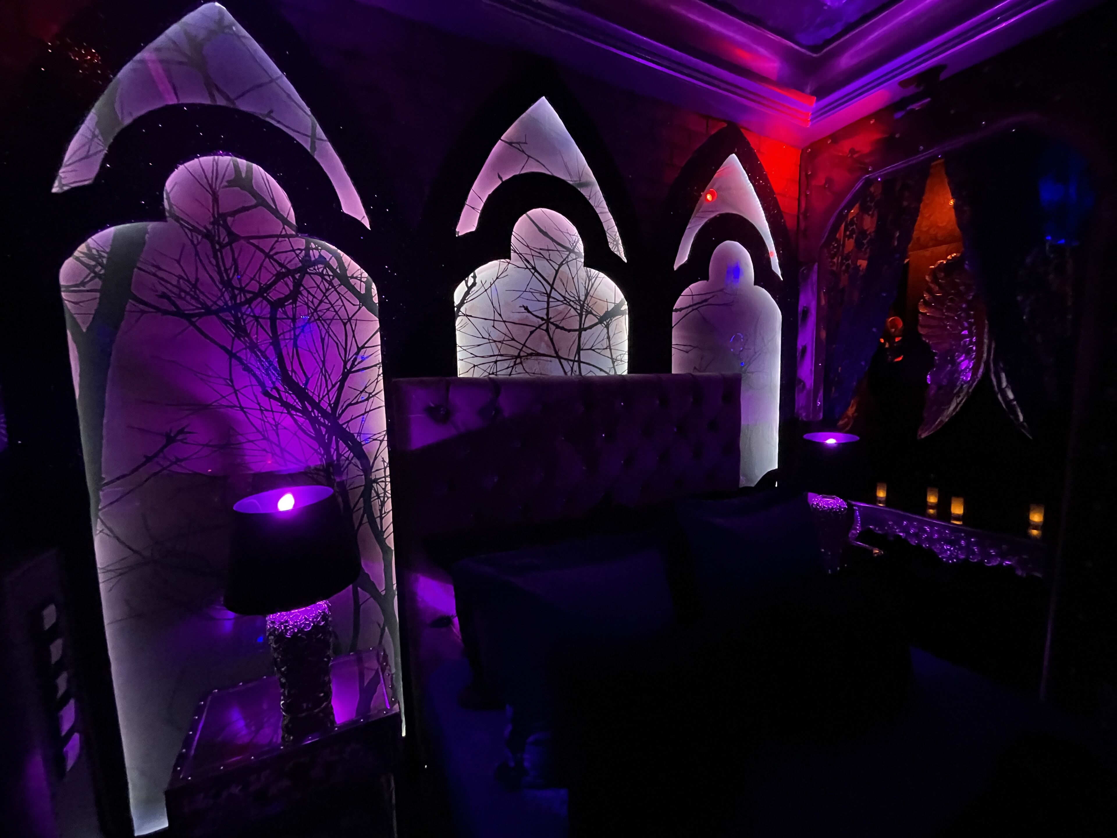 A room with a unique architectural design featuring large, illuminated structures resembling trees and arches.