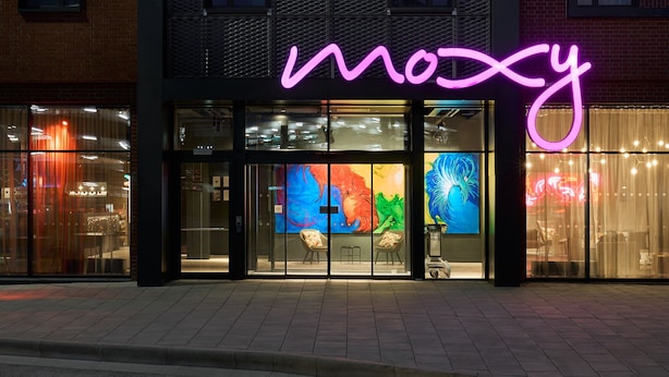 A storefront with a neon sign reading "moosy" and colorful artwork on the glass doors. - Moxy Bristol (Bristol)