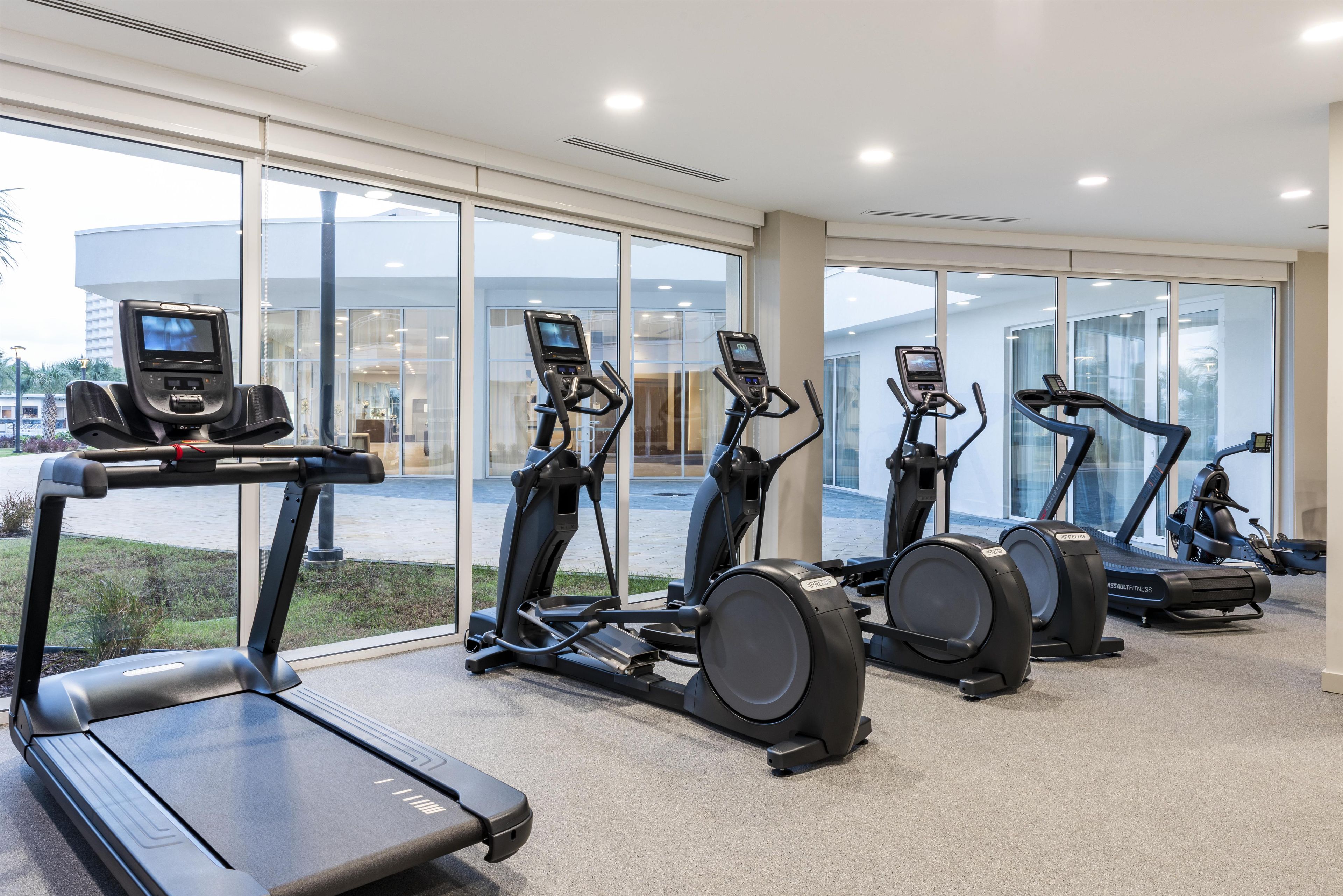 A fitness center with treadmills, ellipticals, and stationary bikes.