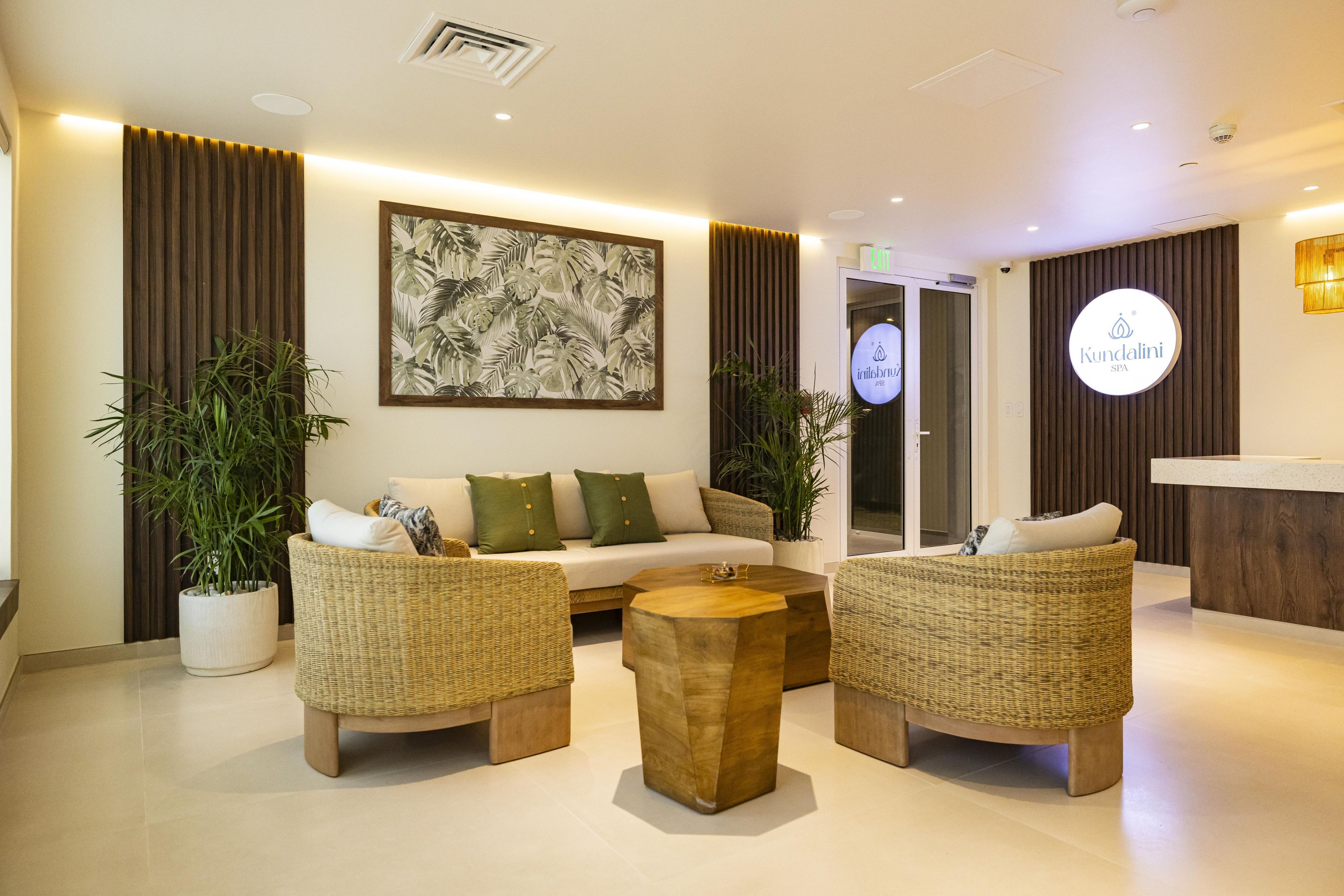 A modern lobby with a reception desk, a sofa set, and potted plants.