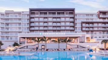 Um hotel com várias varandas, área de piscina e uma placa com a inscrição "Embassy Suites".