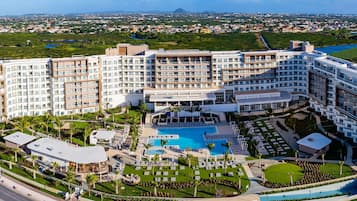 A large hotel with multiple floors, a central pool, and surrounding landscaped areas.