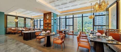 A spacious restaurant with high ceilings, large windows, and modern furnishings.