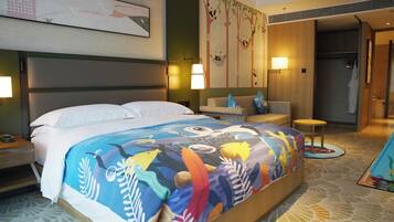 Ein Hotelzimmer mit einem großen Bett, einem Sofa, einem kleinen Tisch und einem durchgegangene Tür sichtbaren Badezimmer.