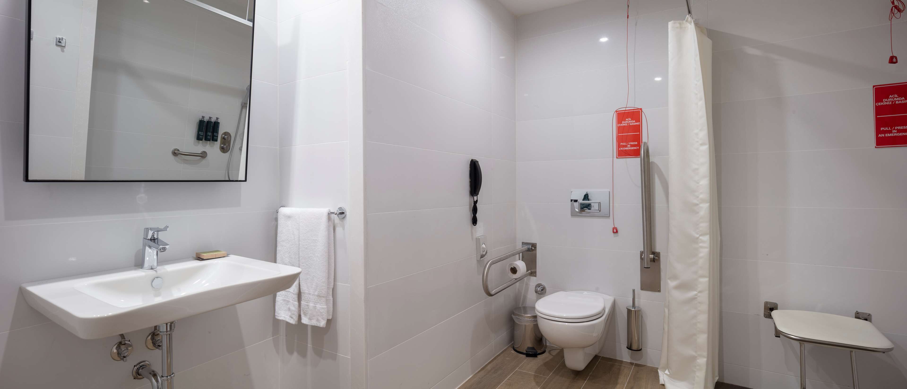 A modern bathroom with a sink, toilet, and shower area.