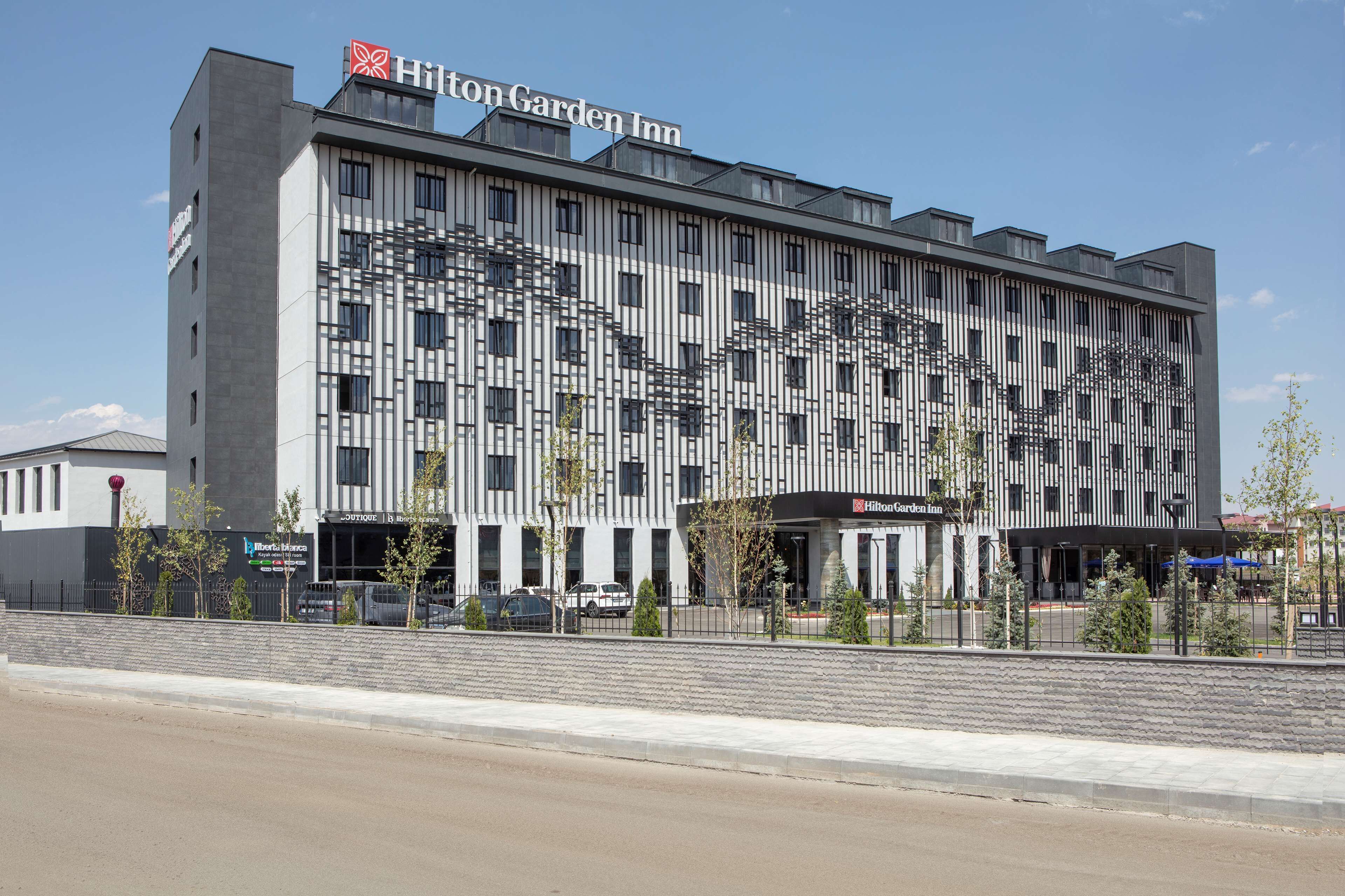 A Hilton Garden Inn with a modern facade, multiple floors, and a prominent entrance.