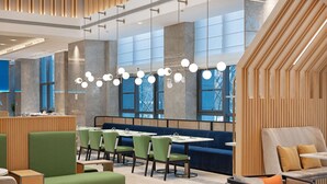 A modern restaurant interior with high ceilings, large windows, and a variety of seating options including booths and tables. - Hilton Garden Inn Rizhao High-Tech Zone (Rizhao)