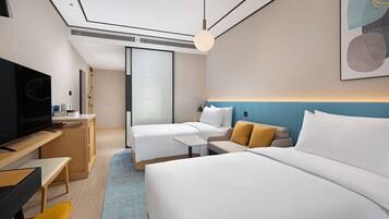 Una habitación de hotel moderna con una cama grande, un escritorio con una silla, un televisor y un sofá.