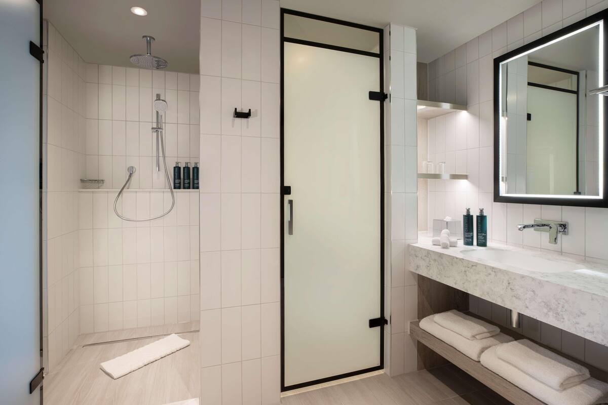Badkamer | Een douche, een haardroger, handdoeken, zeep