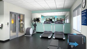 A fitness center with treadmills, a stationary bike, and a rowing machine. There are lockers and a reception area with a clock on the wall. - Tru by Hilton Chesterfield Township Detroit (New Baltimore)