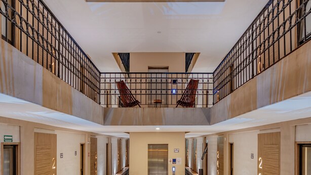 A spacious atrium with a central water feature, multiple floors with balconies, and a modern architectural design. - Hotel Plaza by Kavia (Mérida)