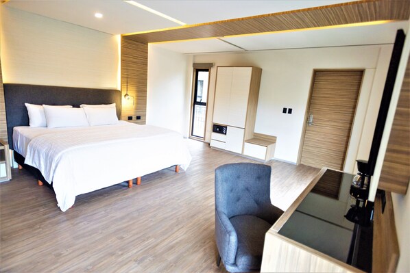 Una habitación de hotel moderna con una cama grande, un escritorio y una silla.