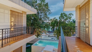 A modern building with balconies, a pool, and a view of the street. - Hotel Plaza by Kavia (Mérida)