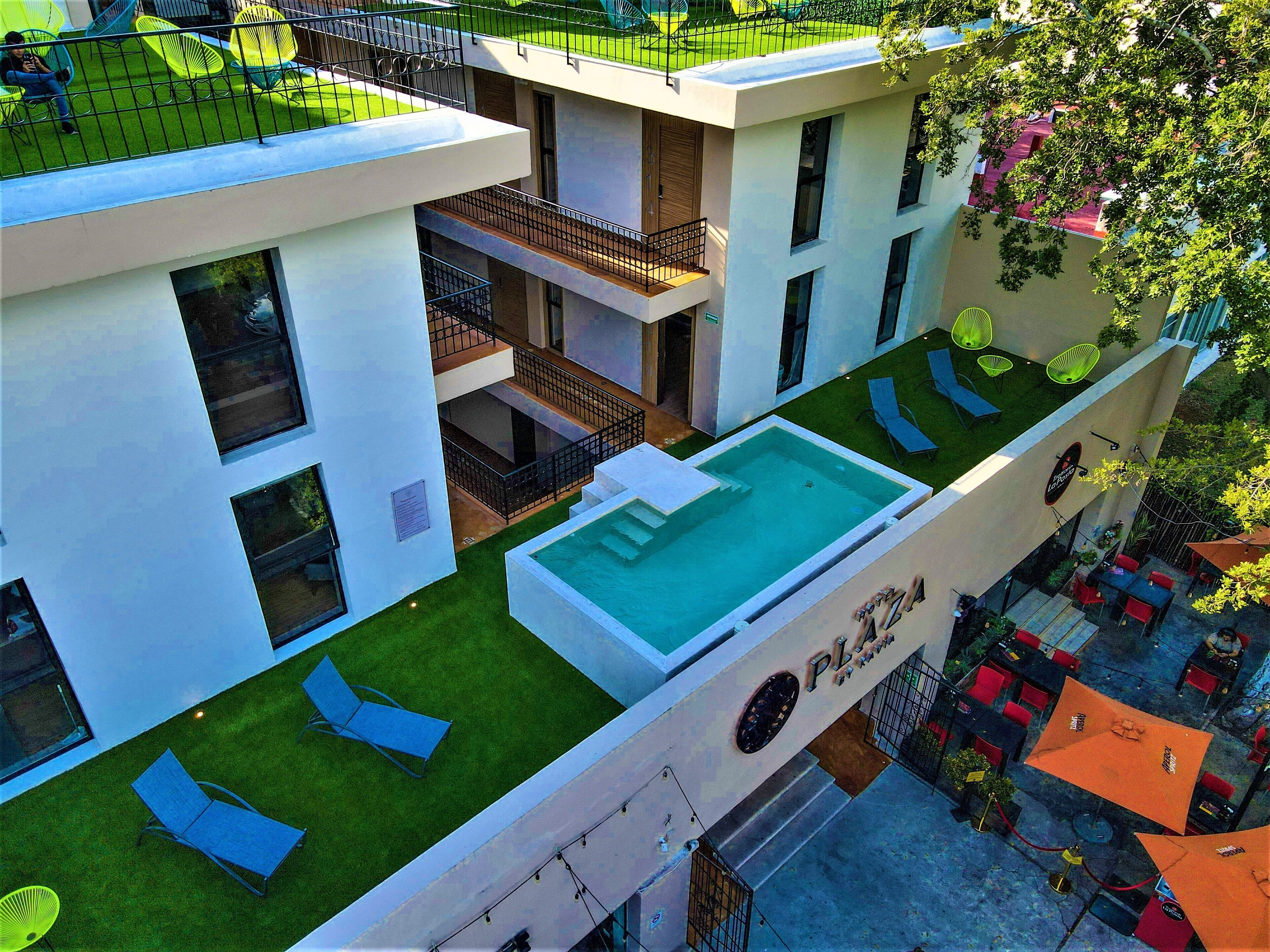 Um edifício moderno com piscina no terraço, várias varandas e áreas de estar ao ar livre.