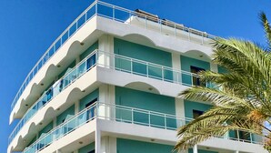 Un hotel de varios pisos con balcones y un cartel que dice "Amalia apts".