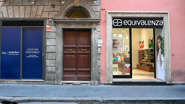 A building with a Sotheby's sign, a brown door, and a store named 'Equivalence' with a visible interior. - Cozy loft next to Spanish Steps (Roma)