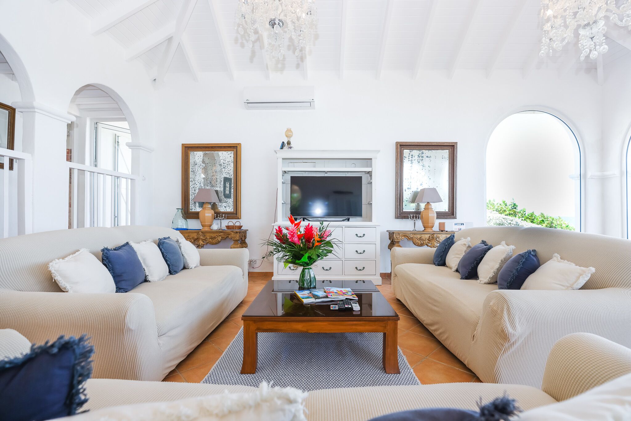 A spacious living room with two sofas, a coffee table, a TV, and decorative items.