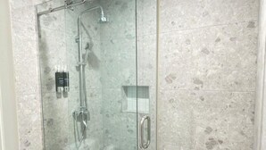 A glass-enclosed shower stall with a white toilet and a small window. - Bushiri's Long Life Building-Studio-Sleeps 2 #2 (Oranjestad)