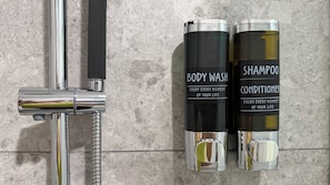 Ein Badezimmer mit einem Chromarmaturen und zwei Flaschen Duschgel und Shampoo.