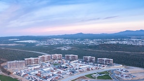 Vista aérea de una zona residencial con varios edificios de apartamentos, calles y zonas verdes circundantes.
