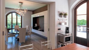 Una cocina moderna con comedor, ventanas amplias y horno empotrado.