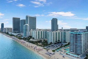 A coastal cityscape with high-rise buildings, a beach, and a pool area. - Beachfront Ocean view 2 bedroom 2 bath Condo in Hollywood Beach Sea Air Towers (Hollywood)