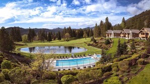 Un complexe hôtelier doté d’une piscine, d’un parcours de golf et offrant une vue sur un paysage montagneux.