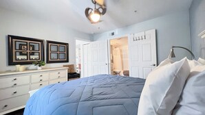A bedroom with a bed, dresser, and two doors leading to other rooms. - Near UF and SHANDS Hospital cozy spot (Gainesville)