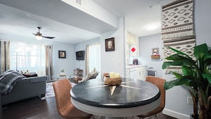A living room with a round table, a sofa, and a television.