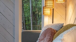 Une chambre confortable avec une fenêtre, un lit moelleux et deux lampes fixées au mur.