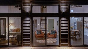 Un intérieur moderne comprenant un coin repas, un ensemble de canapés et un escalier.