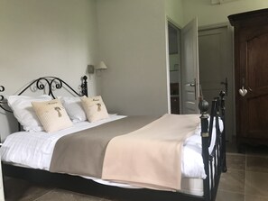Cama bem arrumada com cabeceira, duas almofadas e um cobertor.