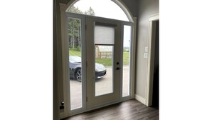 Uma porta com vista para um carro do lado de fora, uma janela com persiana e um piso de madeira.