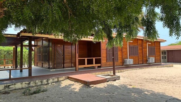 A wooden building with a covered porch and a paved area in front. - Suíte, Vila Alice, Luanda - Angola (Luanda)