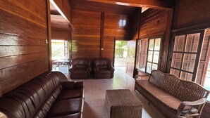 A wooden interior with leather sofas and a wicker bench. - Suíte, Vila Alice, Luanda - Angola (Luanda)