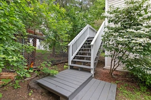 Stairs lead up to a serene building surrounded by lush greenery.