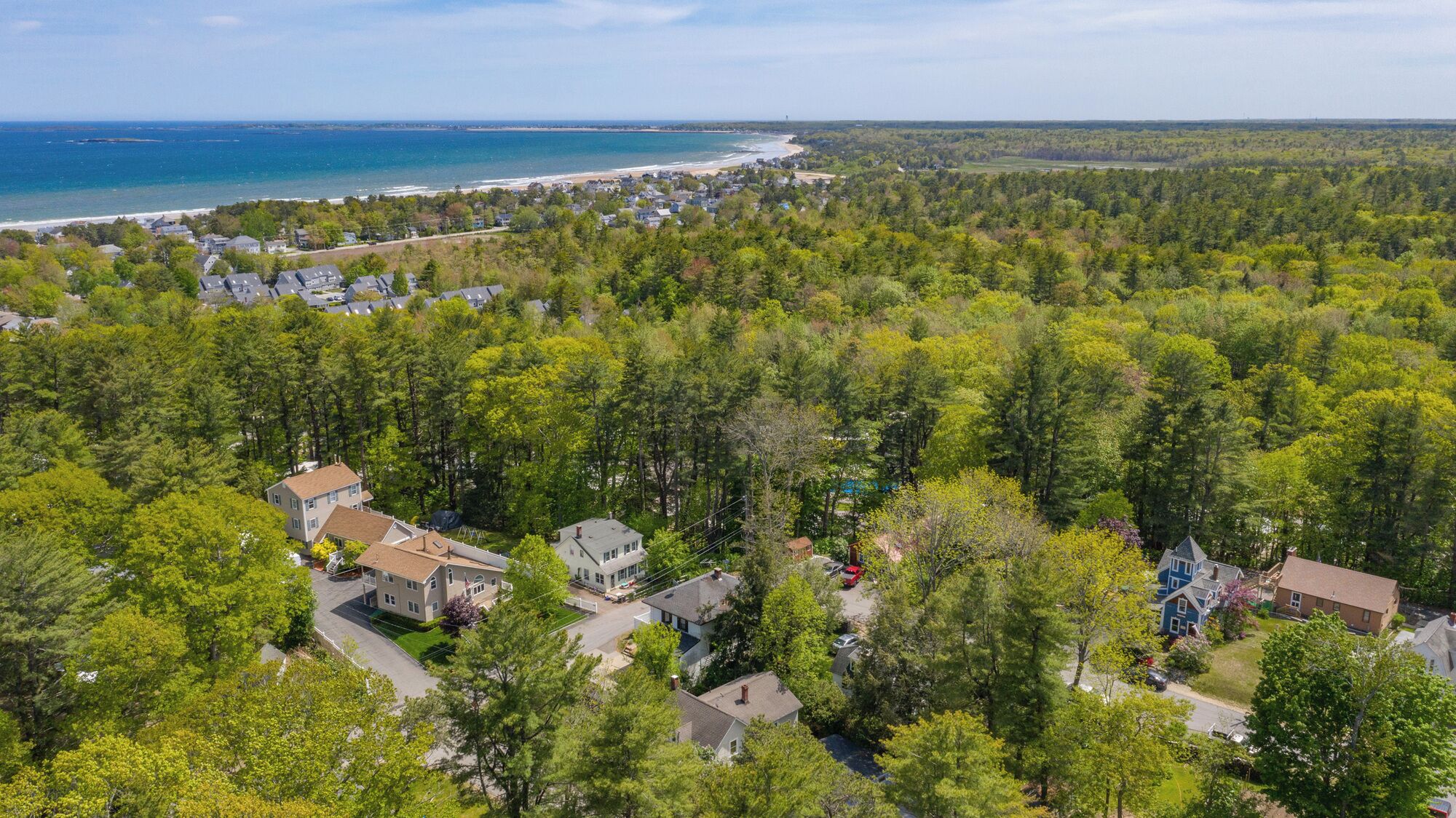 Un quartier résidentiel où les maisons sont entourées d’une forêt dense, à proximité d’une plage, et d’où l’on a une vue dégagée sur l’océan.