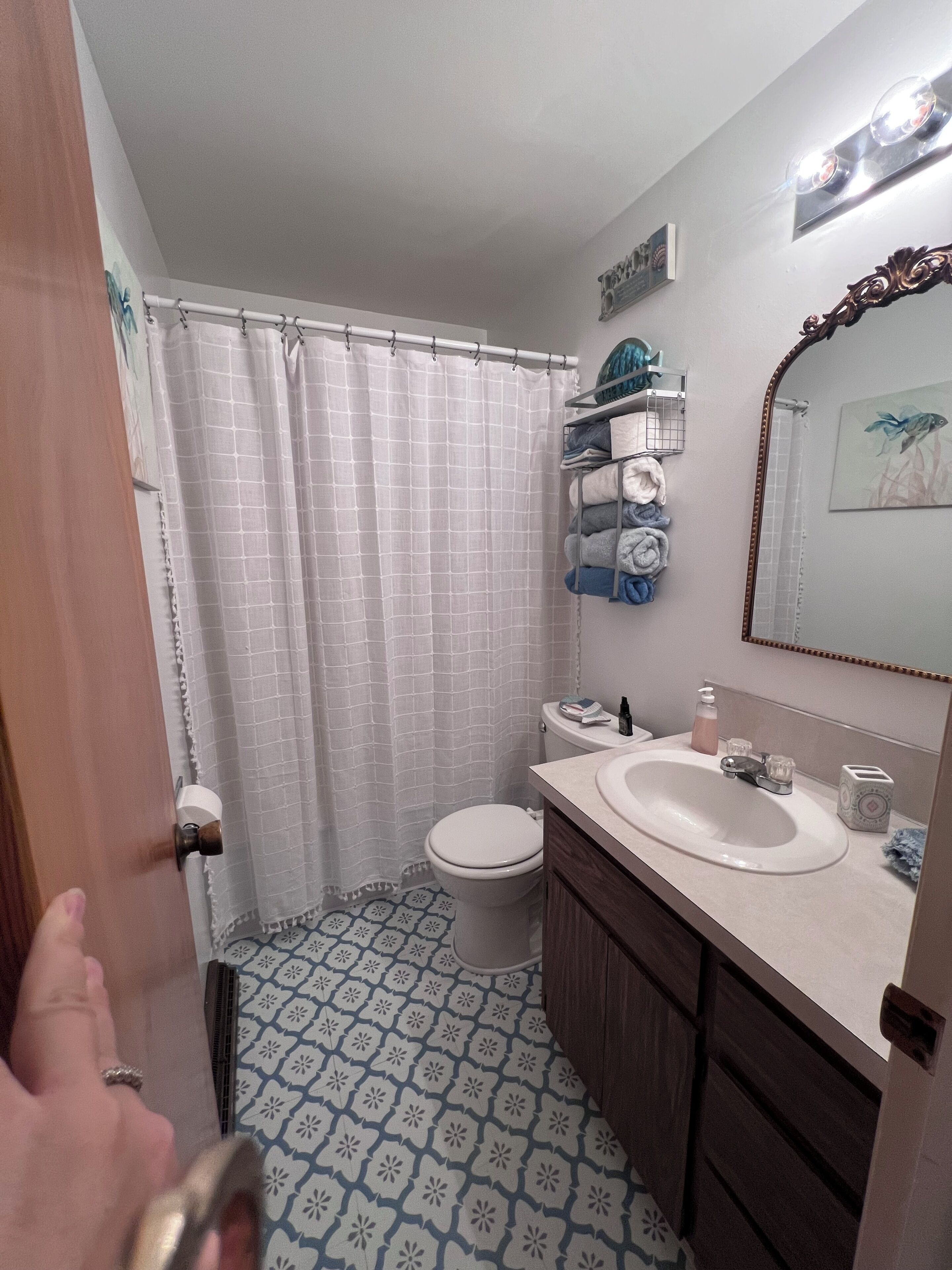 A bathroom with a toilet, sink, and shower curtain.