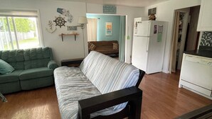 A compact living space with a sofa, a bed, a kitchenette, and a dining area. - Enjoy a Lake Huron view less than a minute walk to the beautiful sandy beach. (Au Gres)